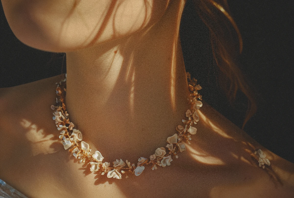 Close-up of a person's neck adorned with a delicate floral necklace